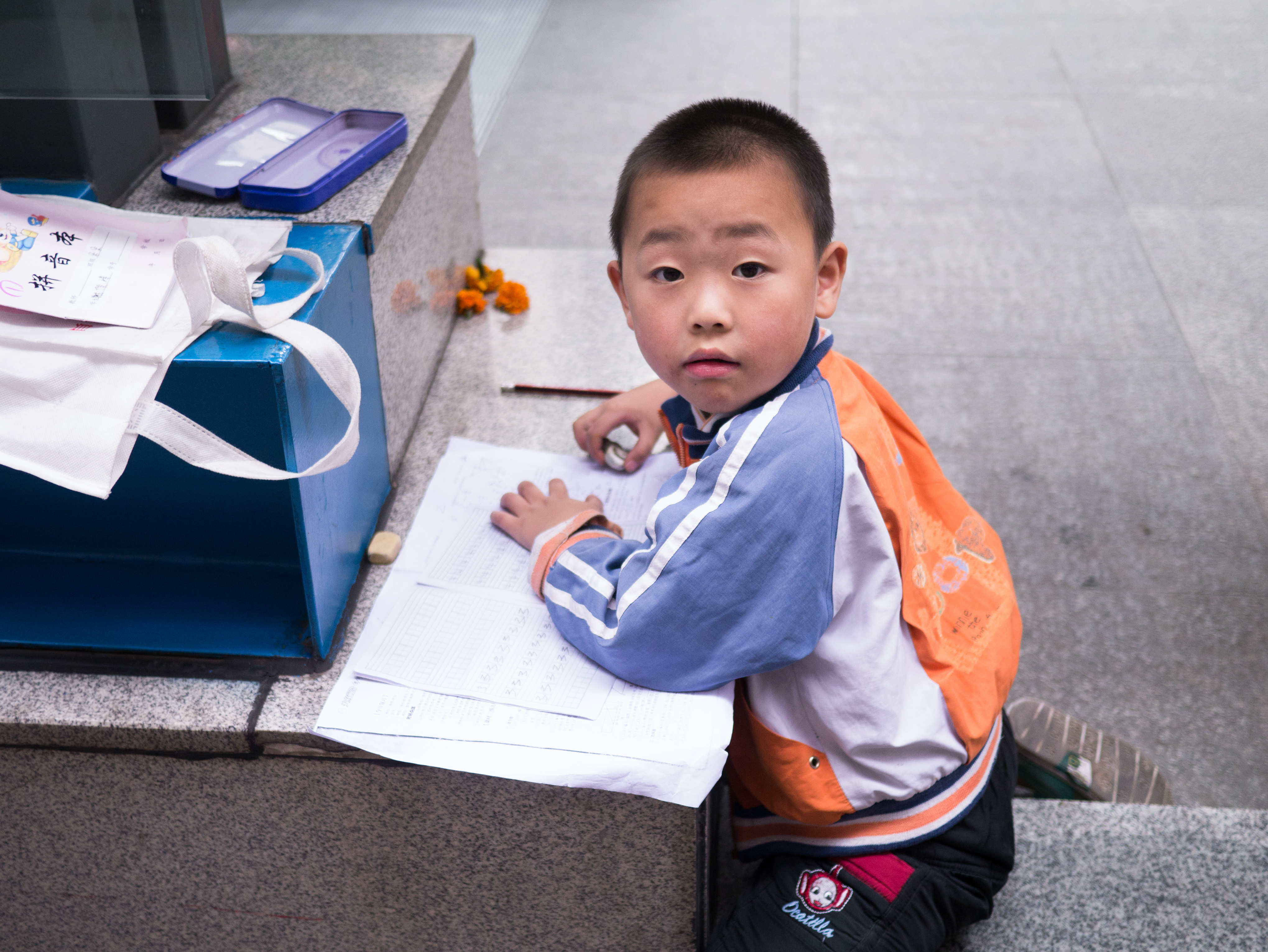 街拍-地铁口写作业的小仔